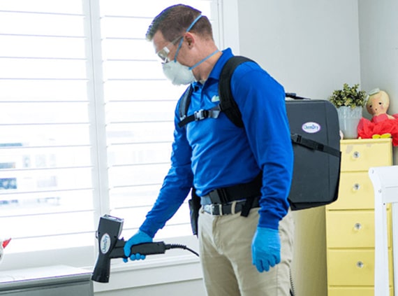 man disinfecting house